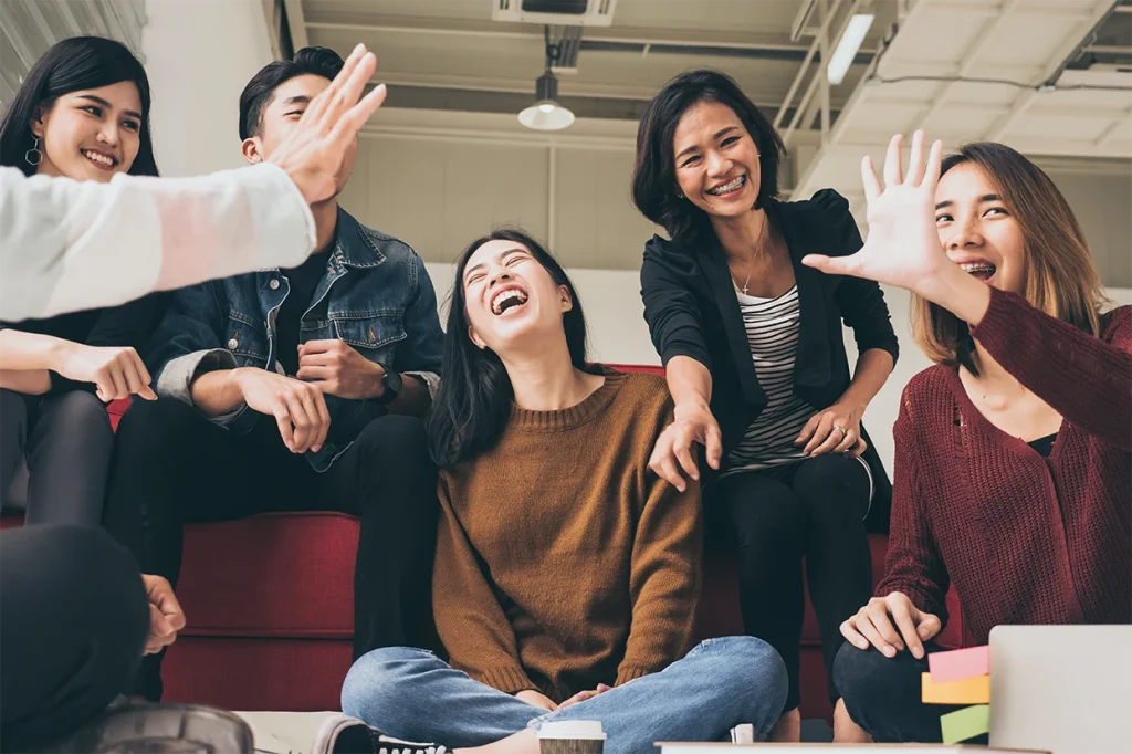 Happy outsourcing professionals enjoying teamwork and positive workplace culture in a modern office in the Philippines